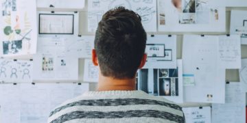 Photo by Startup Stock Photos from Pexels: https://www.pexels.com/photo/man-wearing-black-and-white-stripe-shirt-looking-at-white-printer-papers-on-the-wall-212286/